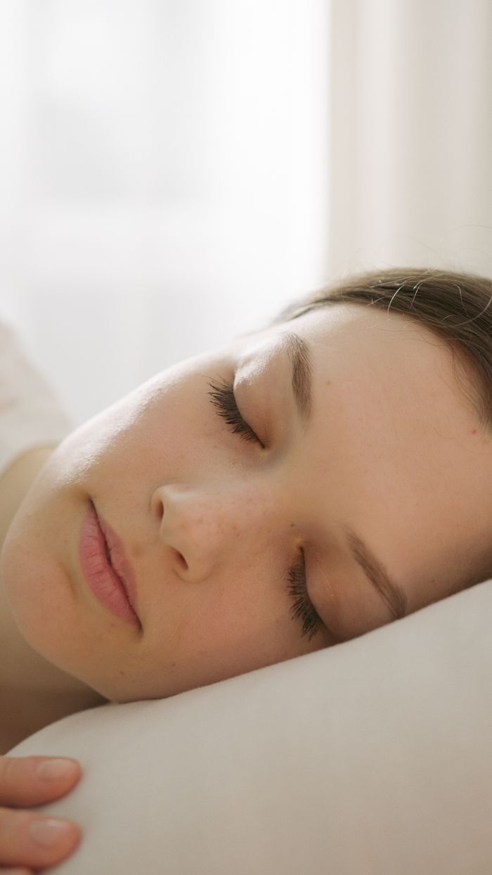 Close-up of a woman peacefully sleeping, showcasing serene relaxation and tranquility.