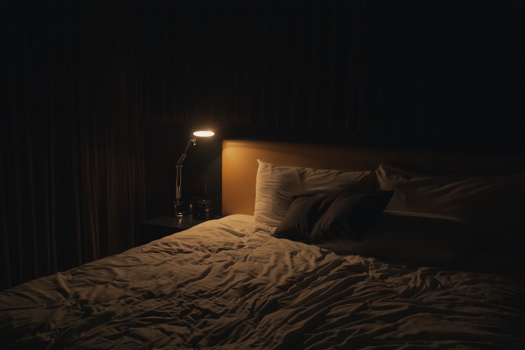 table-lamp-turned-on-near-bed-de9mm2voqkc